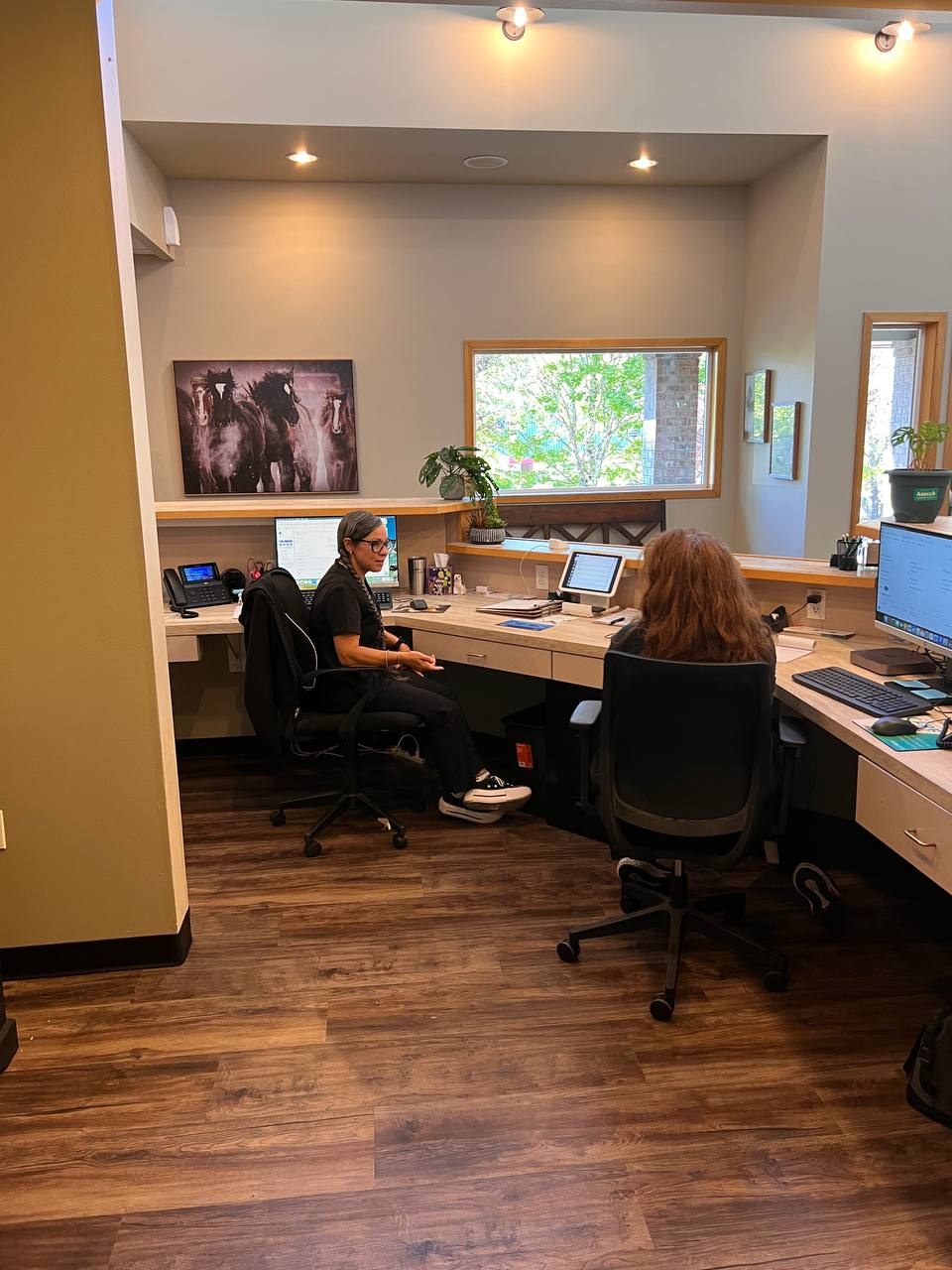 Two team members working at the front-desk workstation