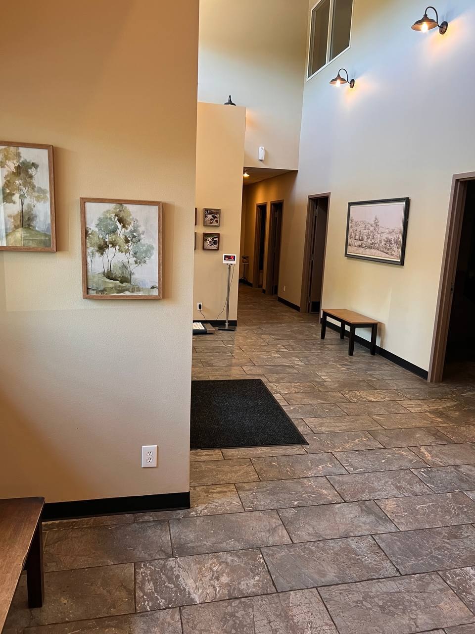 The lobby, with landscape paintings, a bench, and the walk-on scale